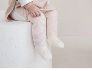 Detalle de calcetines de rayas para bebé sobre la rodilla, calentadores de invierno.