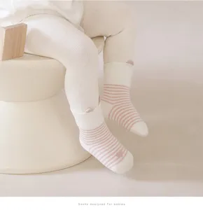 Detailed closeup view of cute baby striped mid-tube socks with small ears in white and pink.