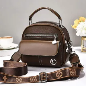 Brown vintage women shoulder bag with top handle, multi-pockets, and stylish monogram strap.