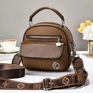 Brown retro shoulder crossbody bag for women with top handle and stylish monogram strap.