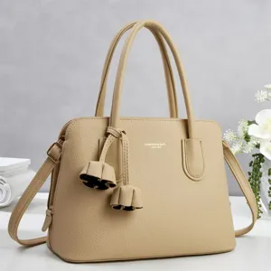 Beige textured leather handbag detail showing fine grain and sturdy double top handles.