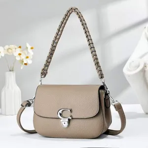 Vue détaillée du sac à bandoulière élégant en cuir taupe avec poignée tressée et fermoir.