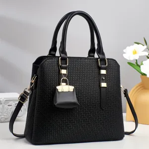 Élégant sac à main noir pour femmes avec anses, bandoulière et détails dorés chics.