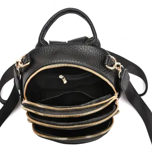 Vue détaillée du mini sac à dos noir avec plusieurs fermetures éclair dorées et compartiments.