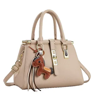 Elegante bolso de mano de cuero beige con asas superiores y lindo dije de caballo.