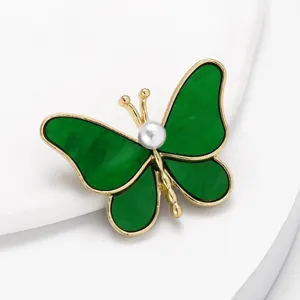 Elegante grüne Schmetterlingsbrosche mit Perle, goldfarbenes Metall, schickes Anzug-Accessoire.