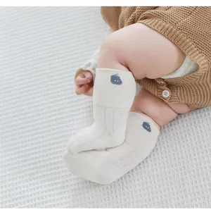 Détail de chaussettes en tricot pour bébé, chaussettes en coton doux avec motif de fruits.