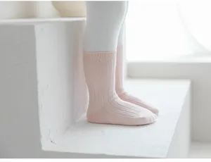 Detalles de calcetines de tubo medio lisos para niños en tejido de punto rosa suave.