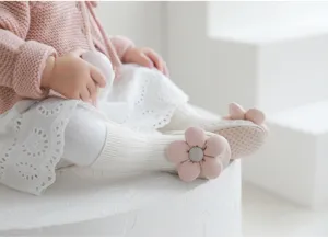 Dettaglio calz-pantofole neonata floreali con grazioso decoro 3D e morbido tessuto.