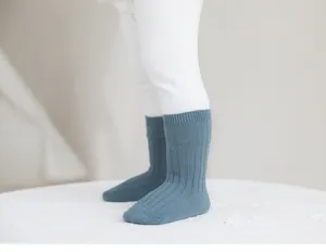 Primer plano de calcetines acanalados azul sólido para niños, detalle de algodón suave blanco.