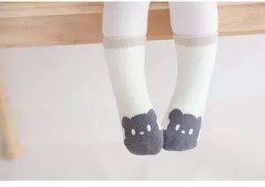 Detailed view of thick baby socks with cute bear pattern, soft knit fabric for winter comfort.