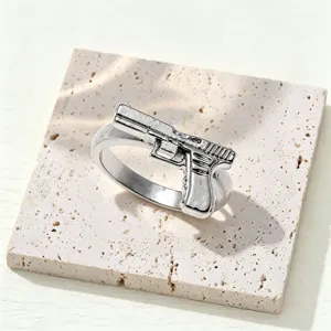 Close-up detail of silver alloy pistol ring, punk style men's jewelry accessory shot.