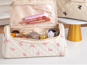 Large capacity quilted cosmetic bag with cute bow pattern, portable travel makeup organizer.