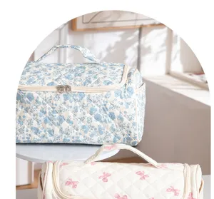 Quilted travel cosmetic bag with floral print and handle, large capacity portable storage.