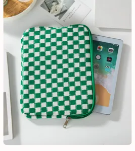 Primo piano della custodia per tablet in maglia a quadri verdi e bianchi su scrivania.