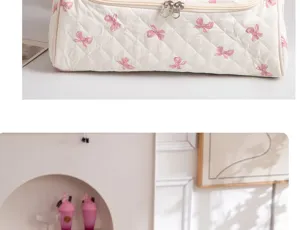 Portable quilted cosmetic travel bag with pink bow print and dual zippers for daily storage.