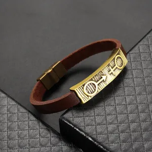 Nahaufnahme des Vintage-Bronze-Metall- und PU-Leder-Paararmbands mit Retro-Symbolen.