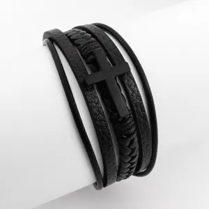Detail view of men's multi-layer black leather braided bracelet with cross charm pendant.