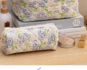 Quilted floral cosmetic pouch detail showing soft fabric texture and neat zipper closure.