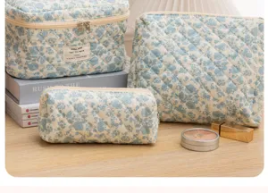 Quilted floral cosmetic bag set, portable storage pouch detail view showing fabric texture.