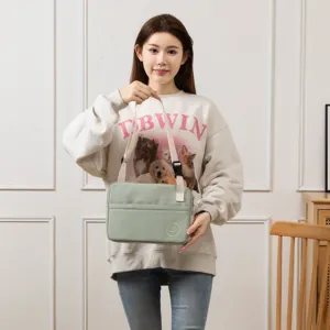 Detailed view of the light green 11-inch tablet sleeve bag with adjustable strap in use.