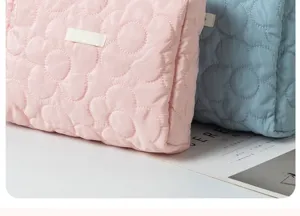 Detail view of the quilted flower cosmetic pouch in pink and blue, soft textured storage bag.