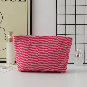 Detail view of the pink and red striped knitted cosmetic pouch, showcasing soft texture and pattern.
