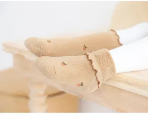 Infant cotton mid-tube socks with cute ruffles and soft non-binding design for babies.