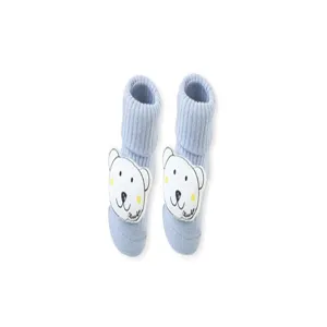 Nahaufnahme von süßen hellblauen Babysocken mit niedlichem weißem Bärchen-Aufnäher und Bündchen.
