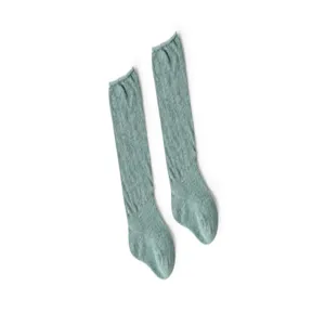 Gros plan sur les chaussettes hautes unies pour bébés avec un détail de texture douce.