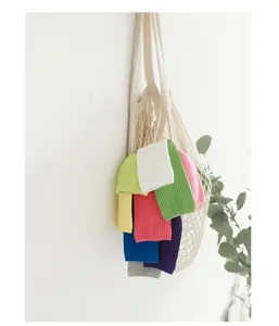 Gedetailleerd uitzicht op kleurrijke geribbelde kindersokken in een nettas voor herfst.