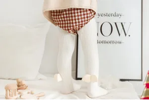 Detailed view of toddler ribbed tights with cute ankle wing design and cozy texture.