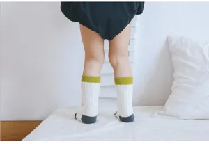Baby mid-calf socks detail shot showing thick knit design, white with green cuff and grey toe.