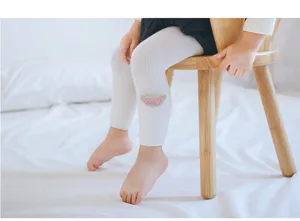 Détail collant bébé, leggings en coton côtelé blanc avec adorable patch rose aux genoux.