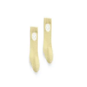 Nahaufnahme der süßen kuscheligen Babysocken mit niedlichem Cartoon-Smiley-Gesicht.