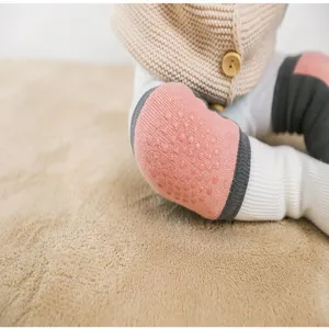 Baby crawler anti-collision knee pad detail shot showing soft pink fabric and silicone grips.
