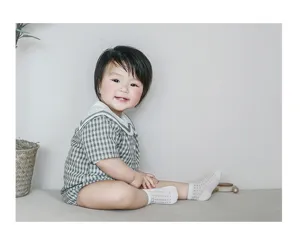 Detailaufnahme von atmungsaktiven Baby-Netz-Sommersocken, getragen im sanften Indoor-Szenario.
