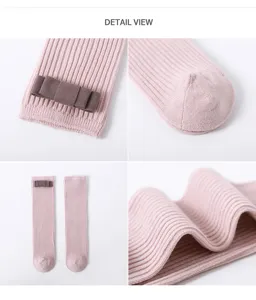 Vue détaillée de chaussettes bébé rose côtelées avec un joli nœud marron et un tissu doux.