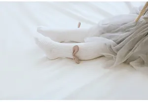 Closeup detail of white baby toddler tights featuring cute angel wings and soft ribbed cotton.