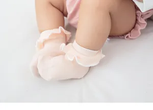 Vue détaillée de chaussettes mignonnes pour bébé à volants en coton doux et délicat.