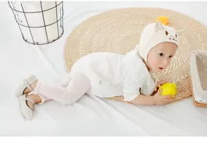 Dettaglio in primo piano delizioso bambino con leggings bianchi e cappello da gatto.