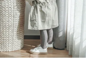 Close-up detail of children ribbed tights, soft combed cotton footed leggings for autumn.