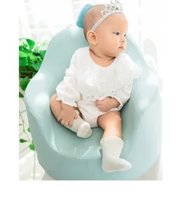 Details van zachte katoenen kanten baby sokjes gedragen door een lief klein kind in stoel.