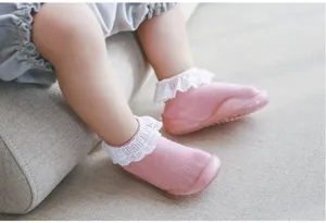 Rosa Baby Lauflernsocken Detail mit süßen weißen Rüschen und weicher Gummisohle.