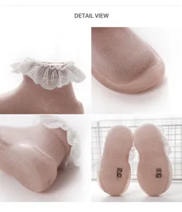 Detailansicht rosafarbener Babyschuhe mit süßer weißer Spitzenrüsche und weicher Gummisohle.