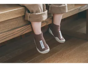 Bequeme braune Kleinkind-Bodensocken mit Gummisohlen fuer Babys beim Laufen und Spielen.