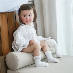 Cute infant baby socks featuring a sweet bow and pom-pom detail, soft ribbed cotton for comfort.