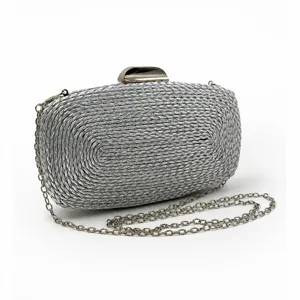 Détail de pochette tissée en PU argenté avec texture délicate, chaîne métal et fermoir.