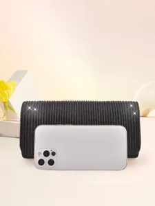 Black pleated evening clutch bag detail showing elegant texture and practical size for parties.