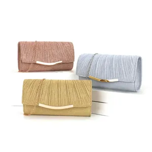 Details of the elegant pleated evening clutch bag with metallic chain and curved closure.
